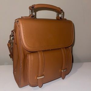 Small brown shoulder purse with snap enclosures.